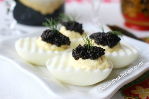 Photo Black caviar serving on eggs Russian style